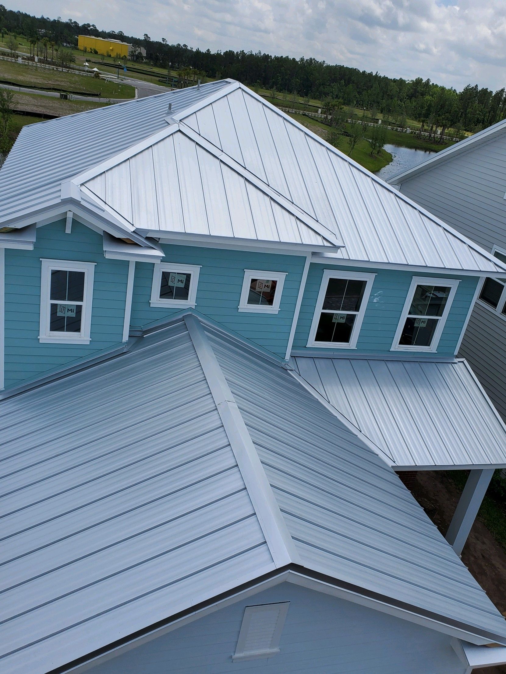 Blue house with a silver metal roof.