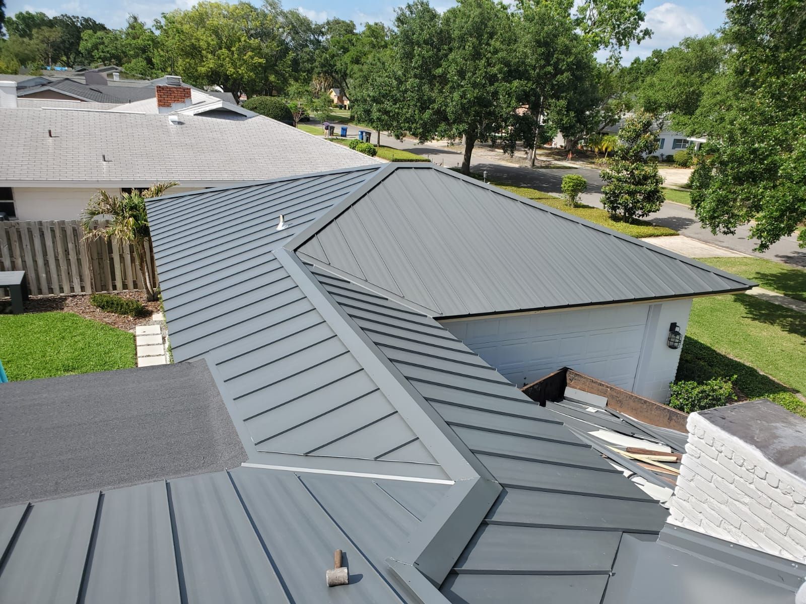 Gray metal roof on a residential building, seen from above on a sunny day.