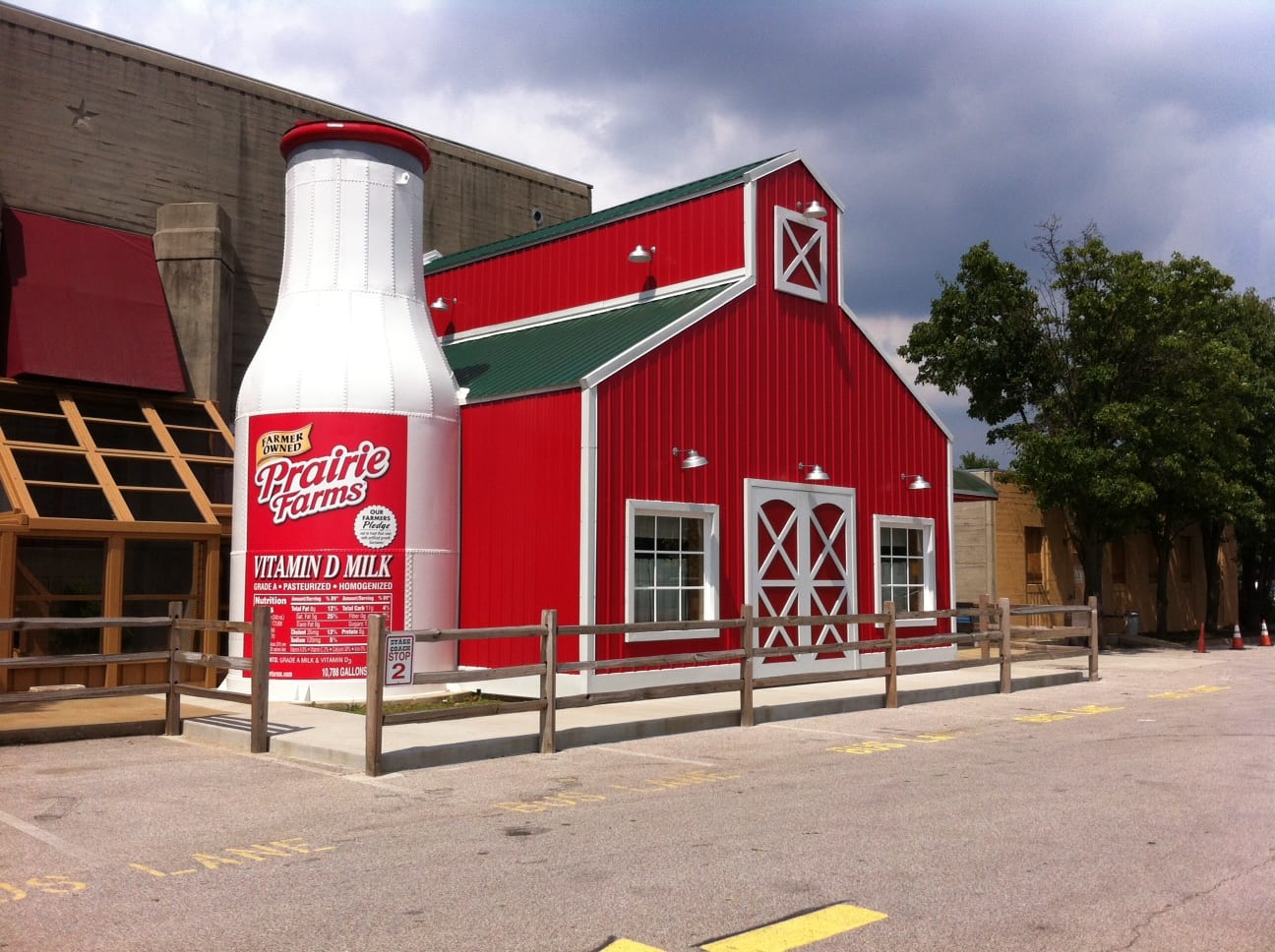 Red barn building with giant milk bottle in front.