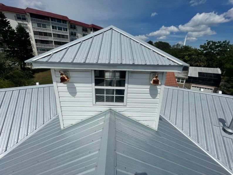 White building with a metal roof and a small window.