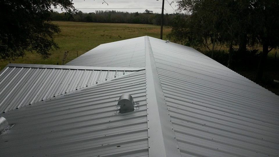 Metal roof with vent, in outdoor setting.