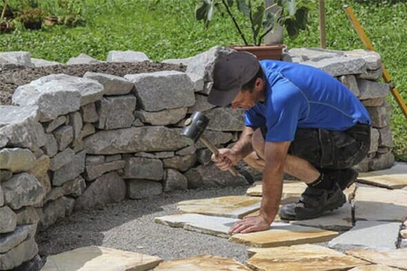 Man Repairing Garden Tiles — Valley Maintenance & Landscape Inc in St. Charles, IL