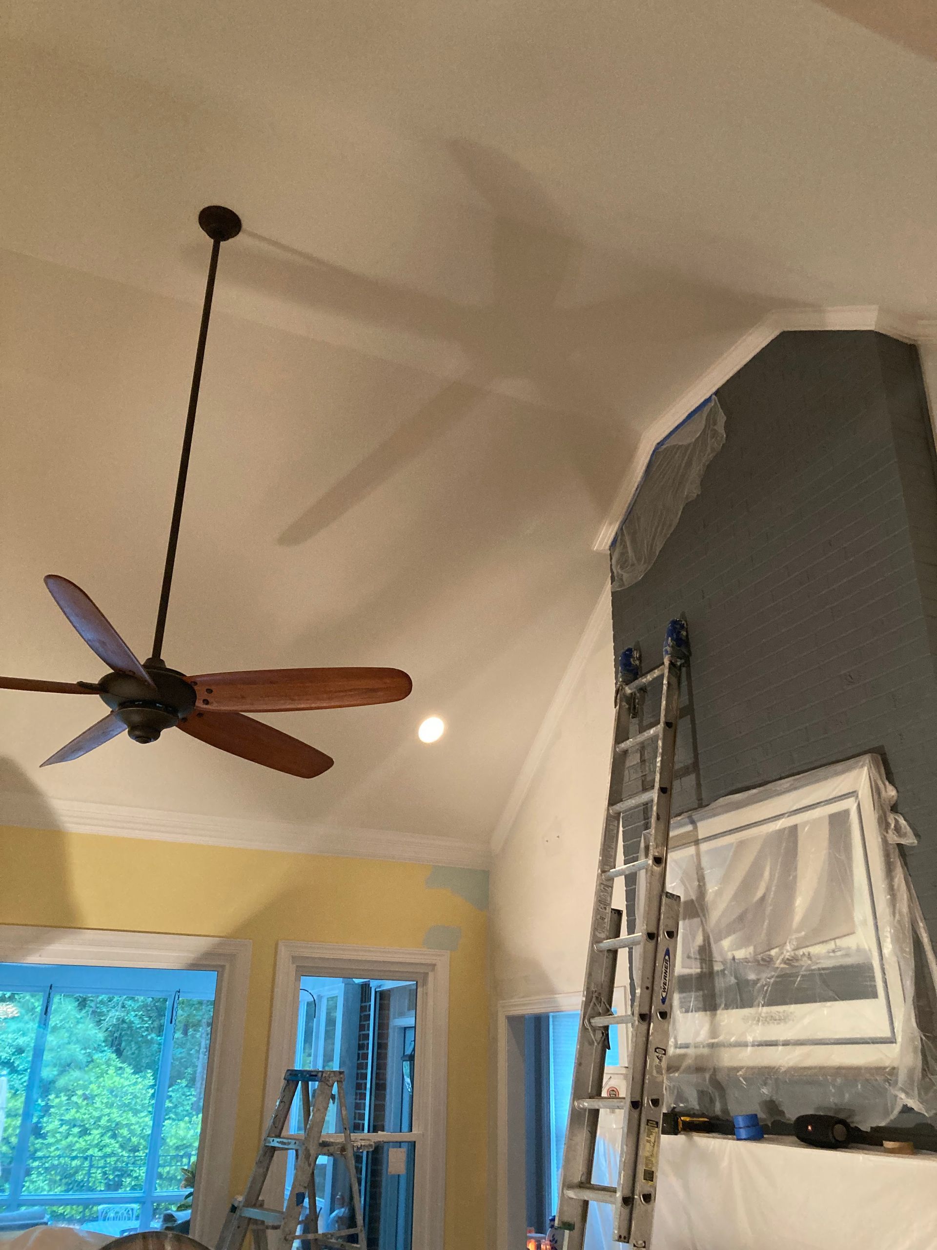A ceiling fan is hanging from the ceiling of a living room.