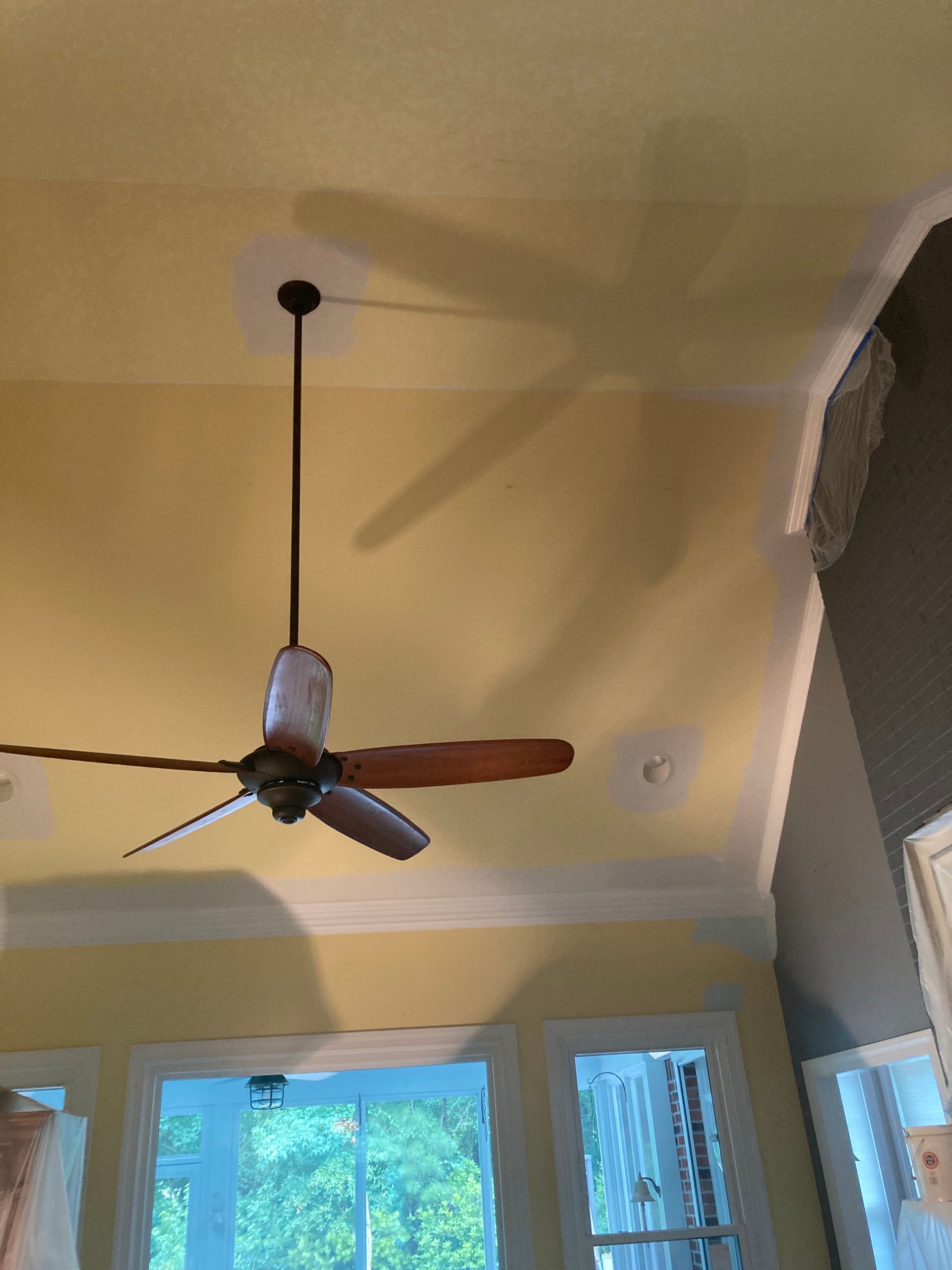 A ceiling fan is hanging from the ceiling of a room.