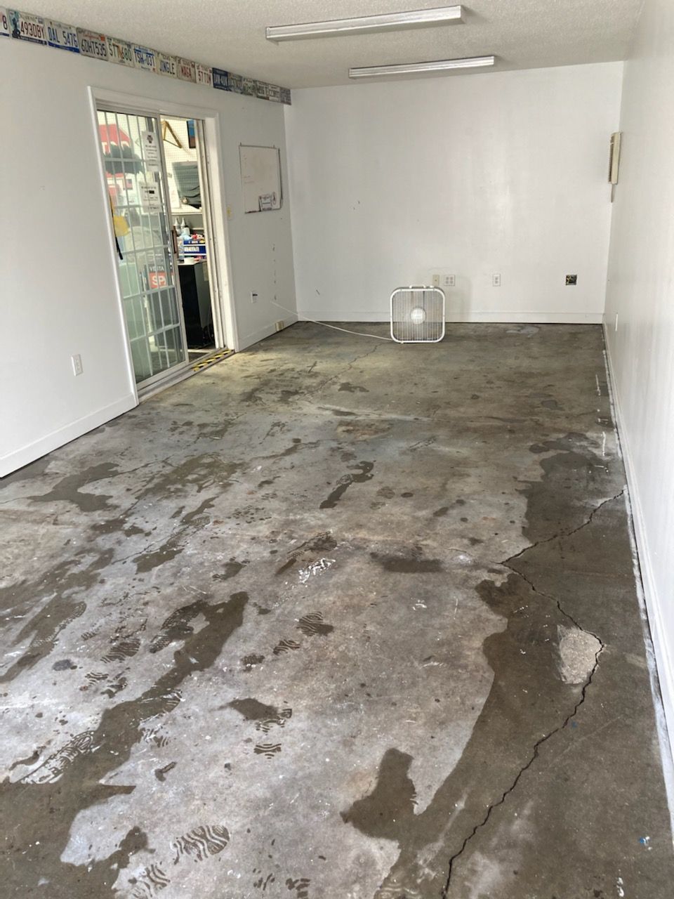 An empty room with a concrete floor and white walls.