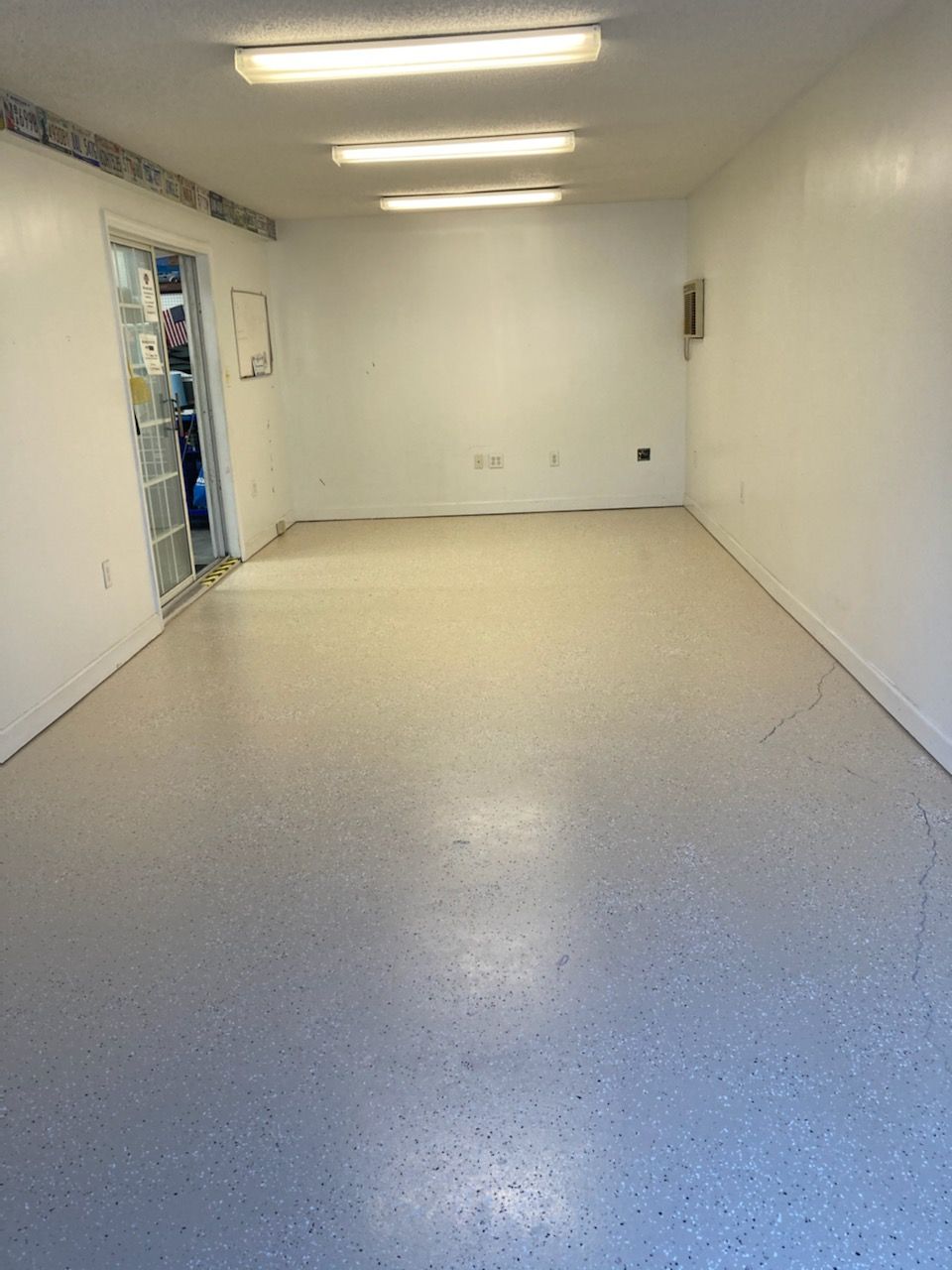 A large empty room with a white floor and white walls.