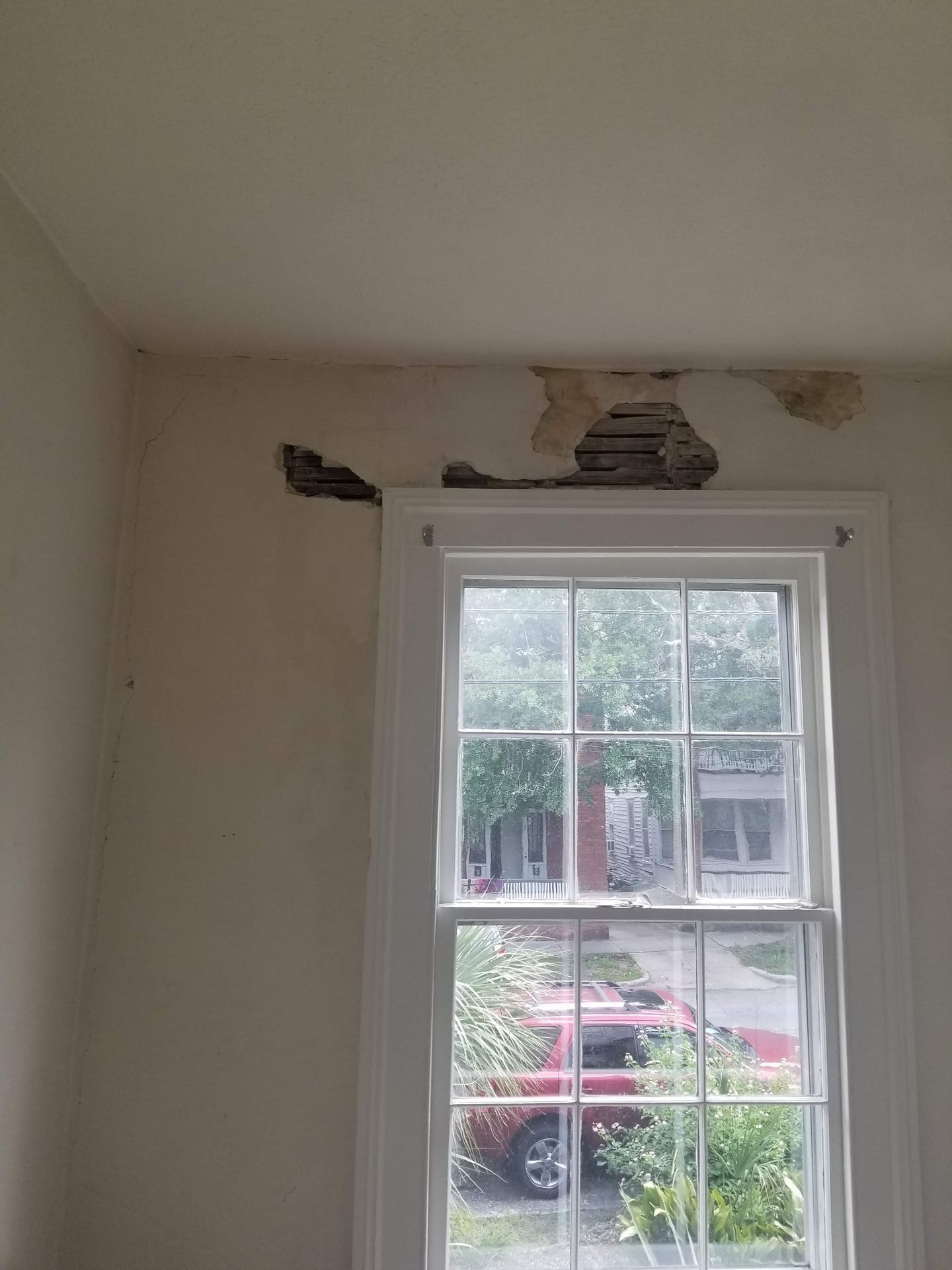 A room with a window and a car in the background