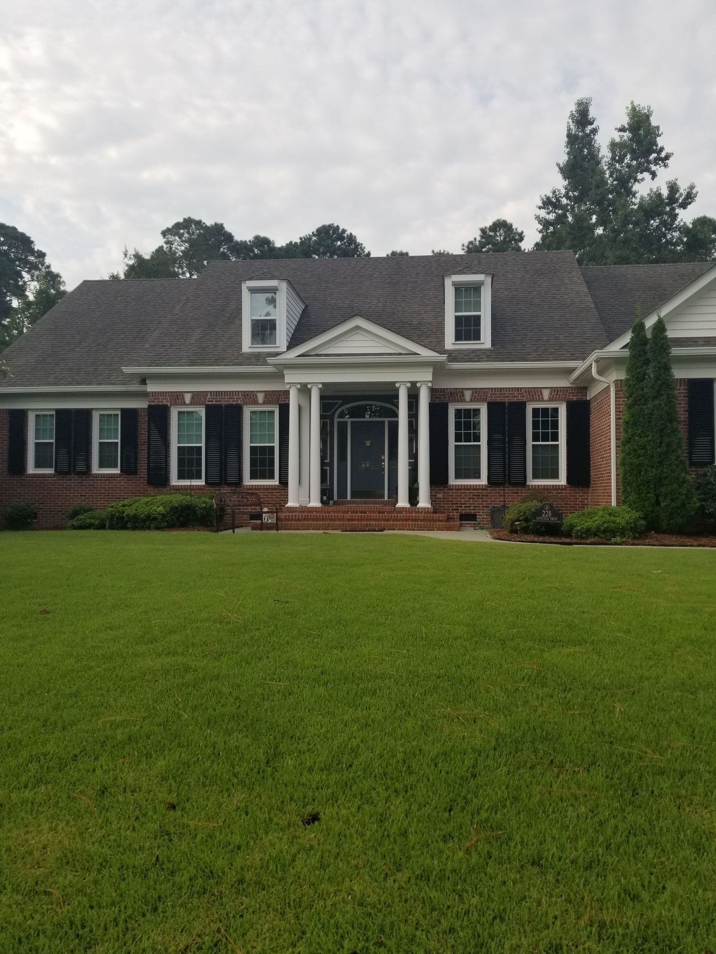 A large brick house with black shutters on the windows