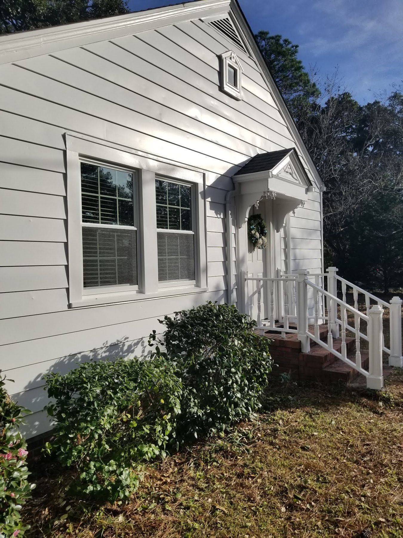 A white house with a white porch and stairs