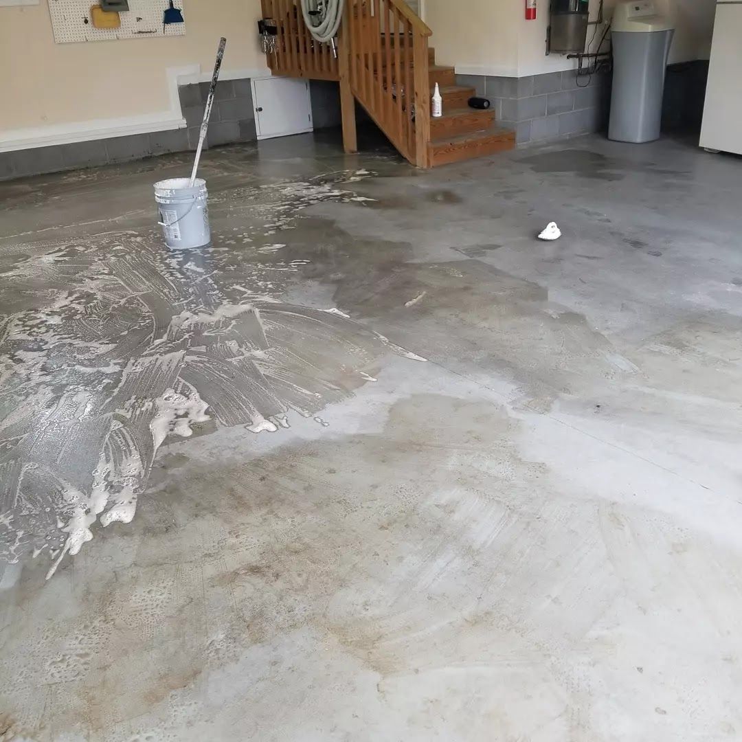 A bucket of water is sitting on the floor of a garage.