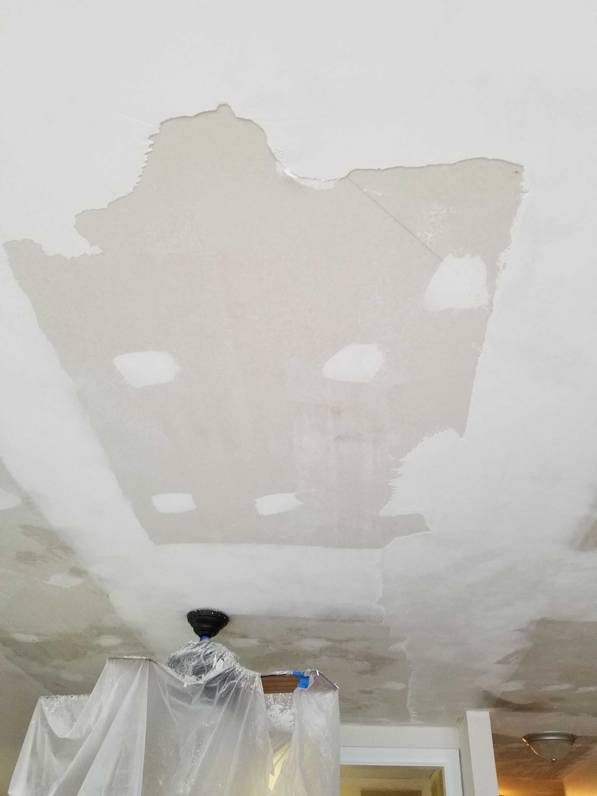 A person is painting a ceiling in a room.