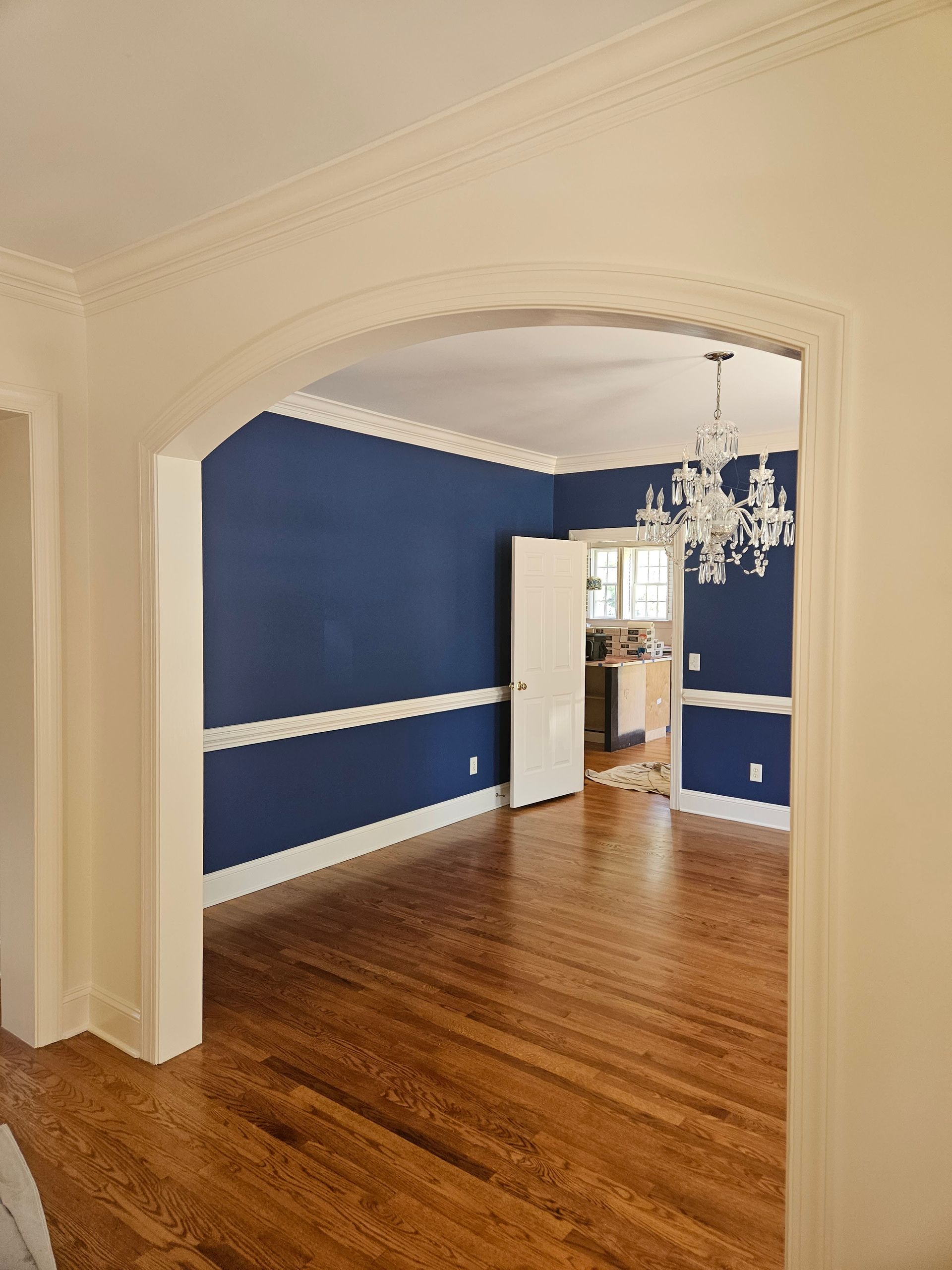 An empty room with blue walls and hardwood floors
