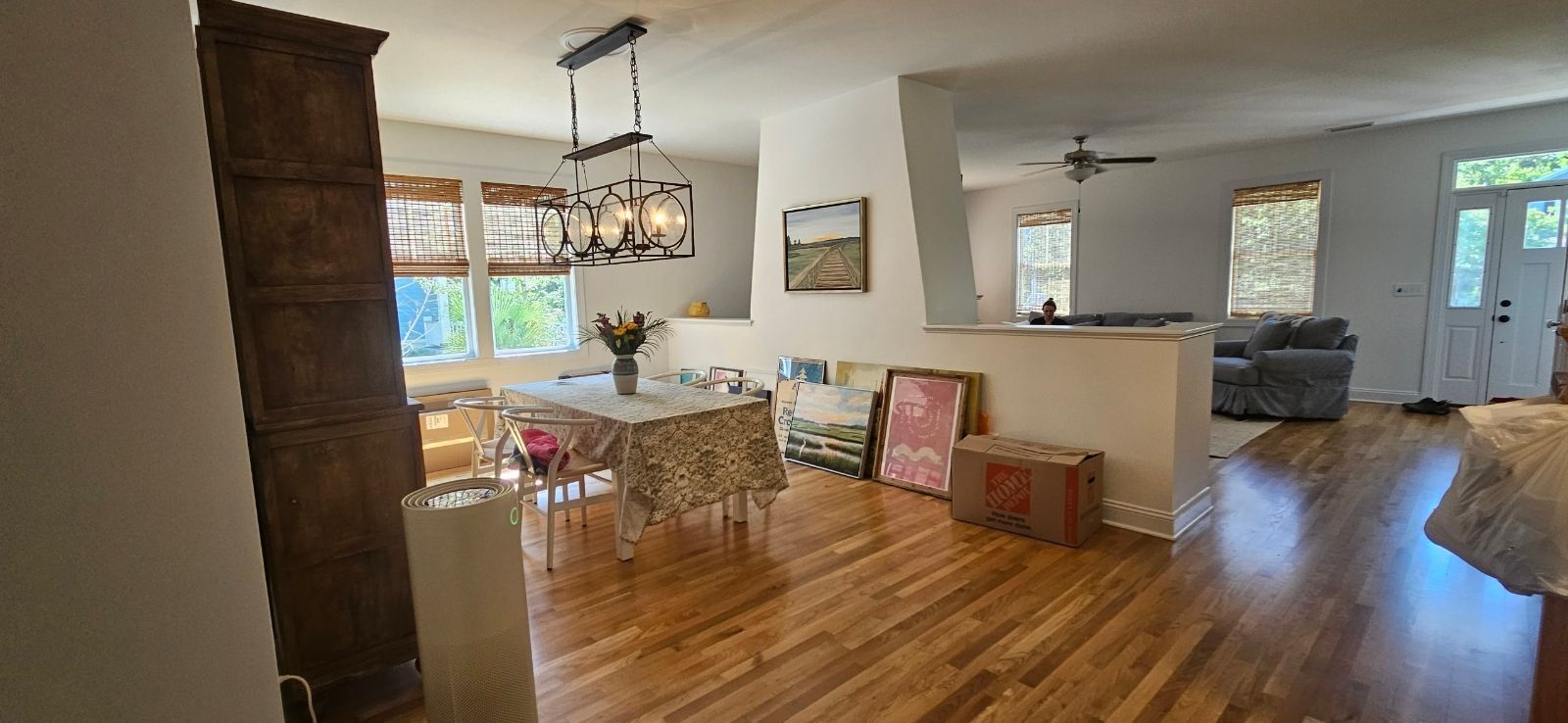 Interior view of a dining area with wooden floors, a table, and a built-in bookcase.
