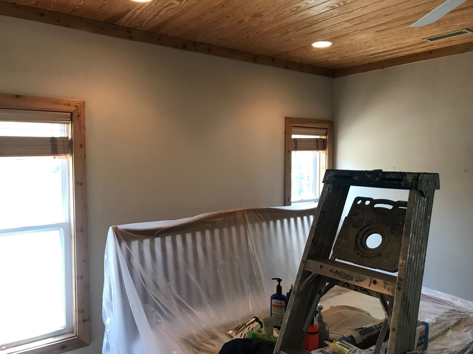 A wooden ladder is sitting on top of a bed in a room.