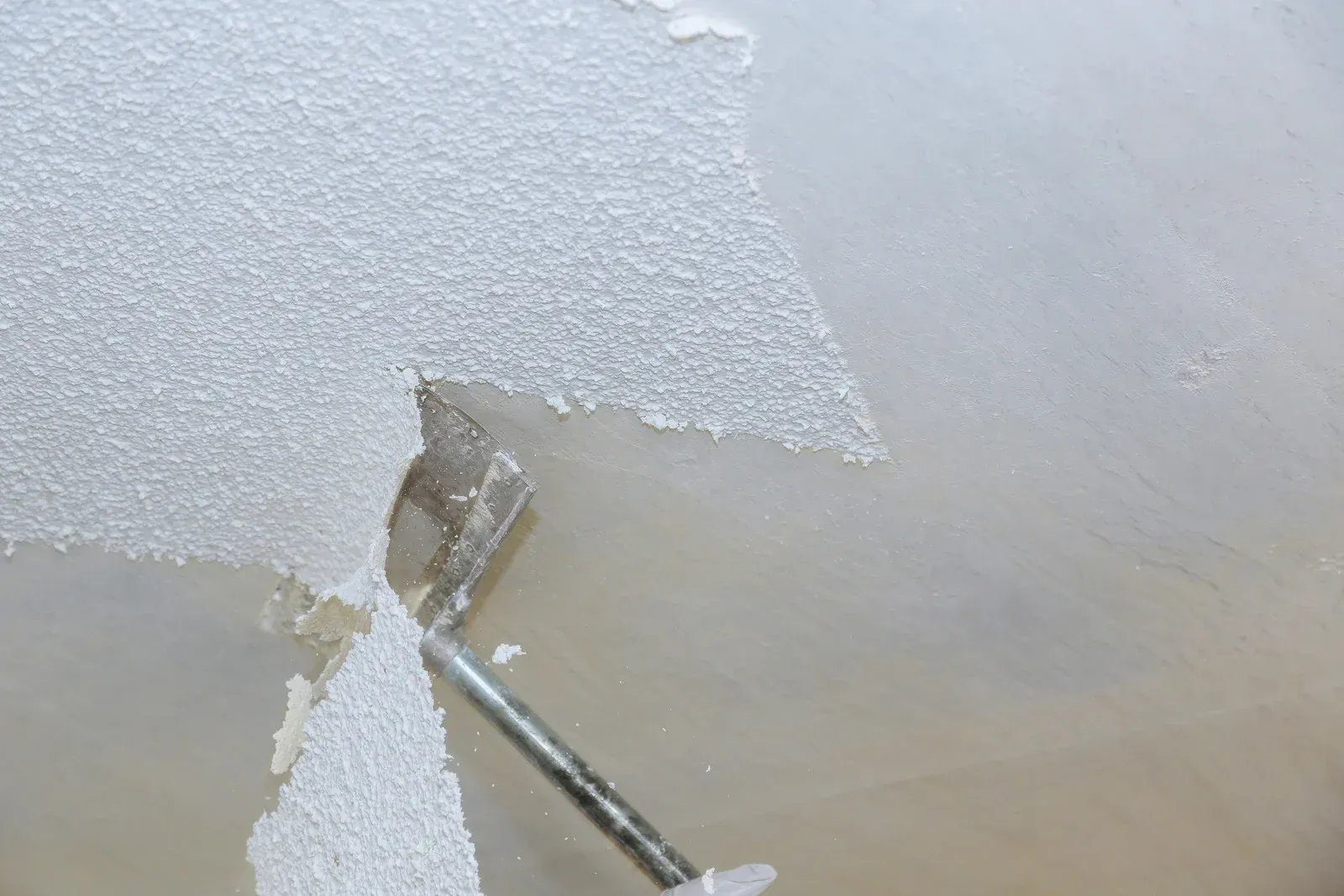 A man is working on a ceiling with a screwdriver.