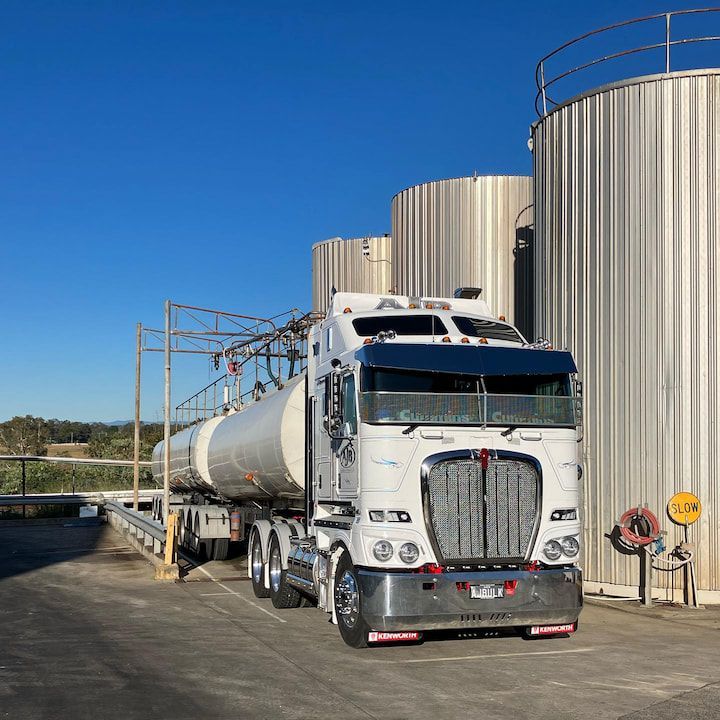 A Tanker Truck is Parked in Front of a Row of Tanks — Andrew Johnston Haulage In Ewingsdale, NSW