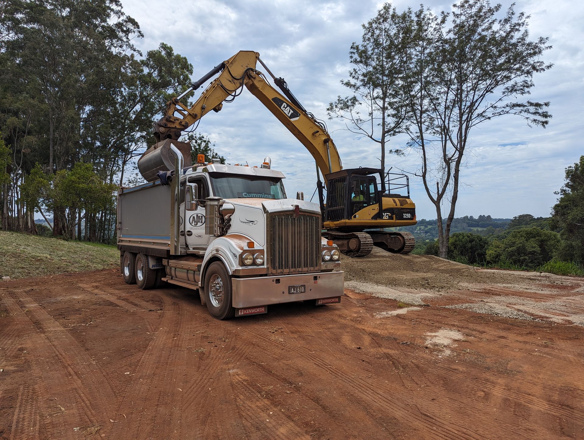 A Dump Truck is Being Loaded With Dirt by an Excavator — Andrew Johnston Haulage In Ewingsdale, NSW