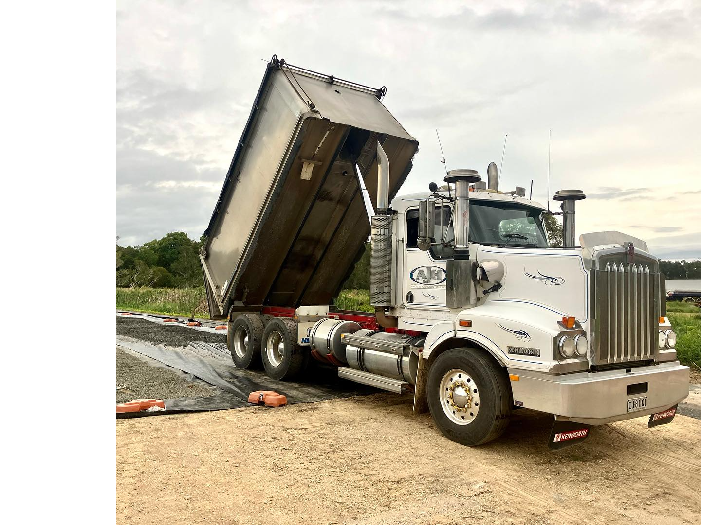A Dump Truck Is Dumping Gravel On A Construction Site — Andrew Johnston Haulage In Ewingsdale, NSW
