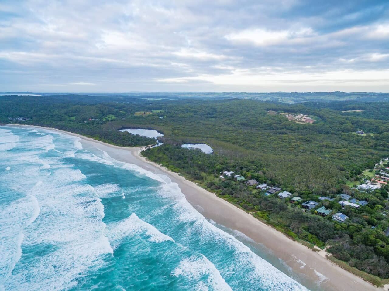An Aerial View of a Beach Surrounded by Trees and Waves — Andrew Johnston Haulage In Suffolk, NSW