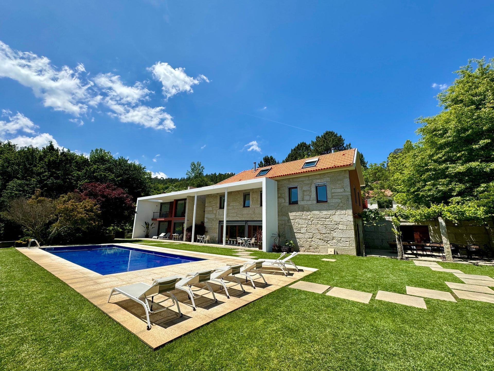 Uma casa grande com piscina em frente