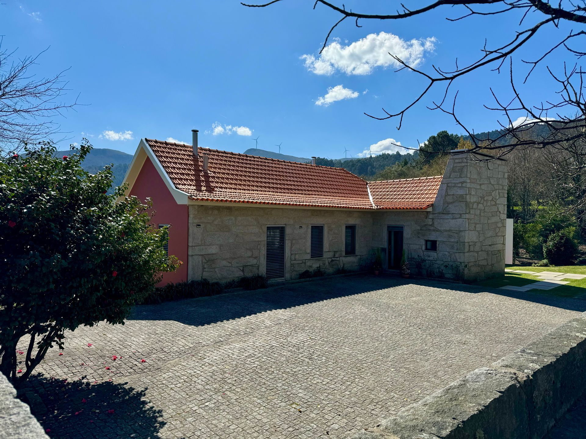Uma casa com telhado vermelho é cercada por árvores