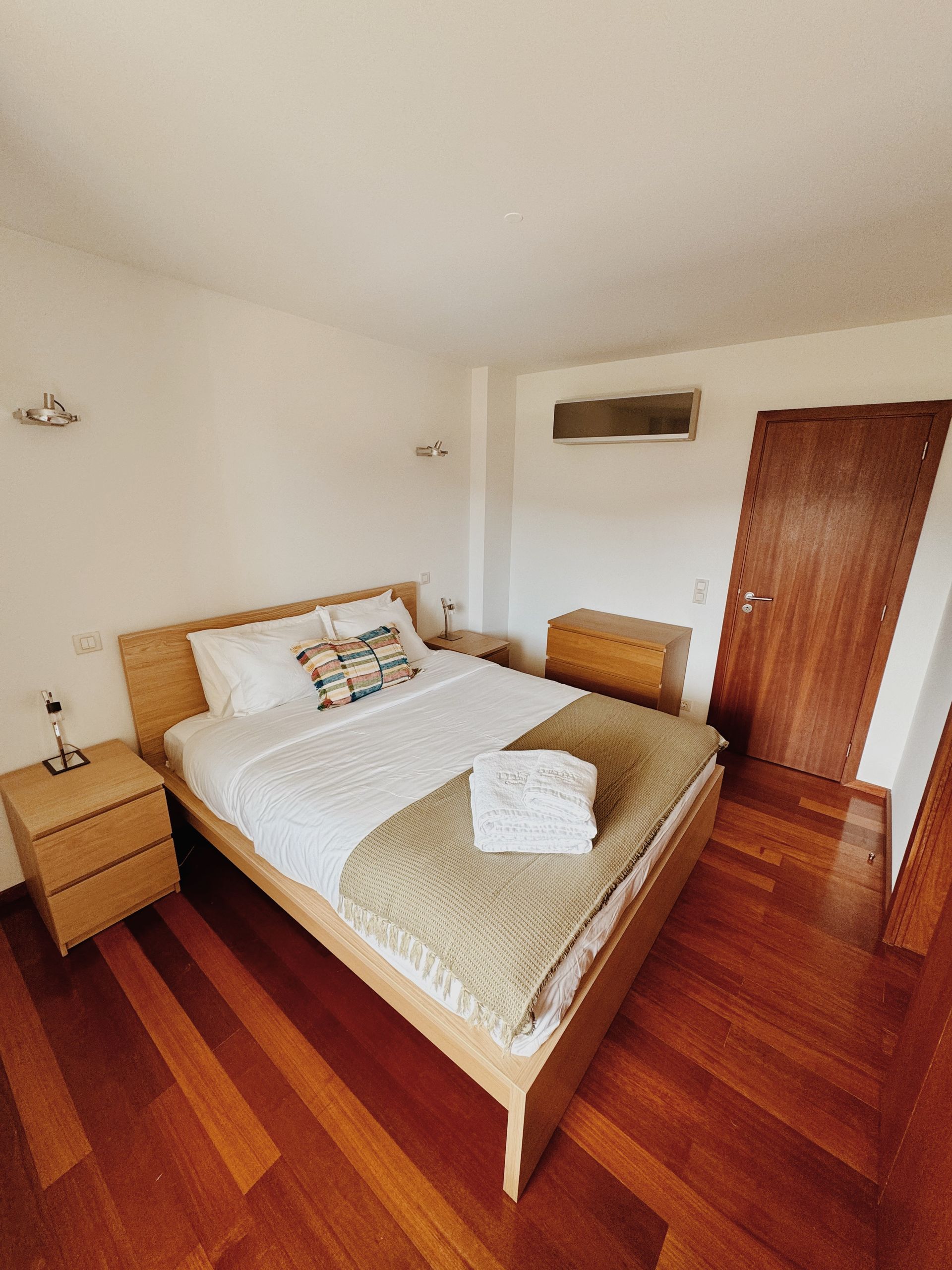 Um quarto com cama king size e piso de madeira