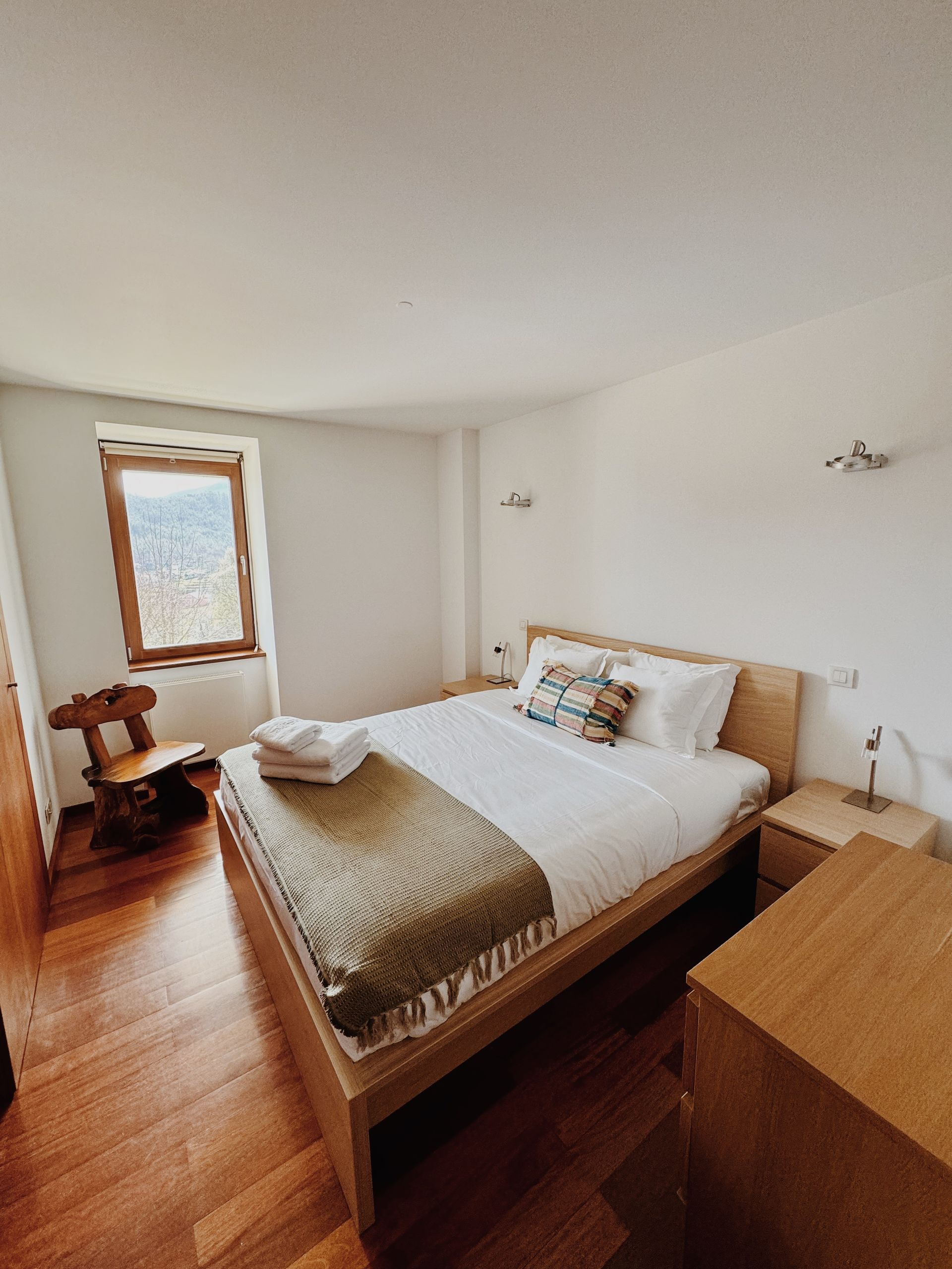 Há uma cama grande no meio do quarto.