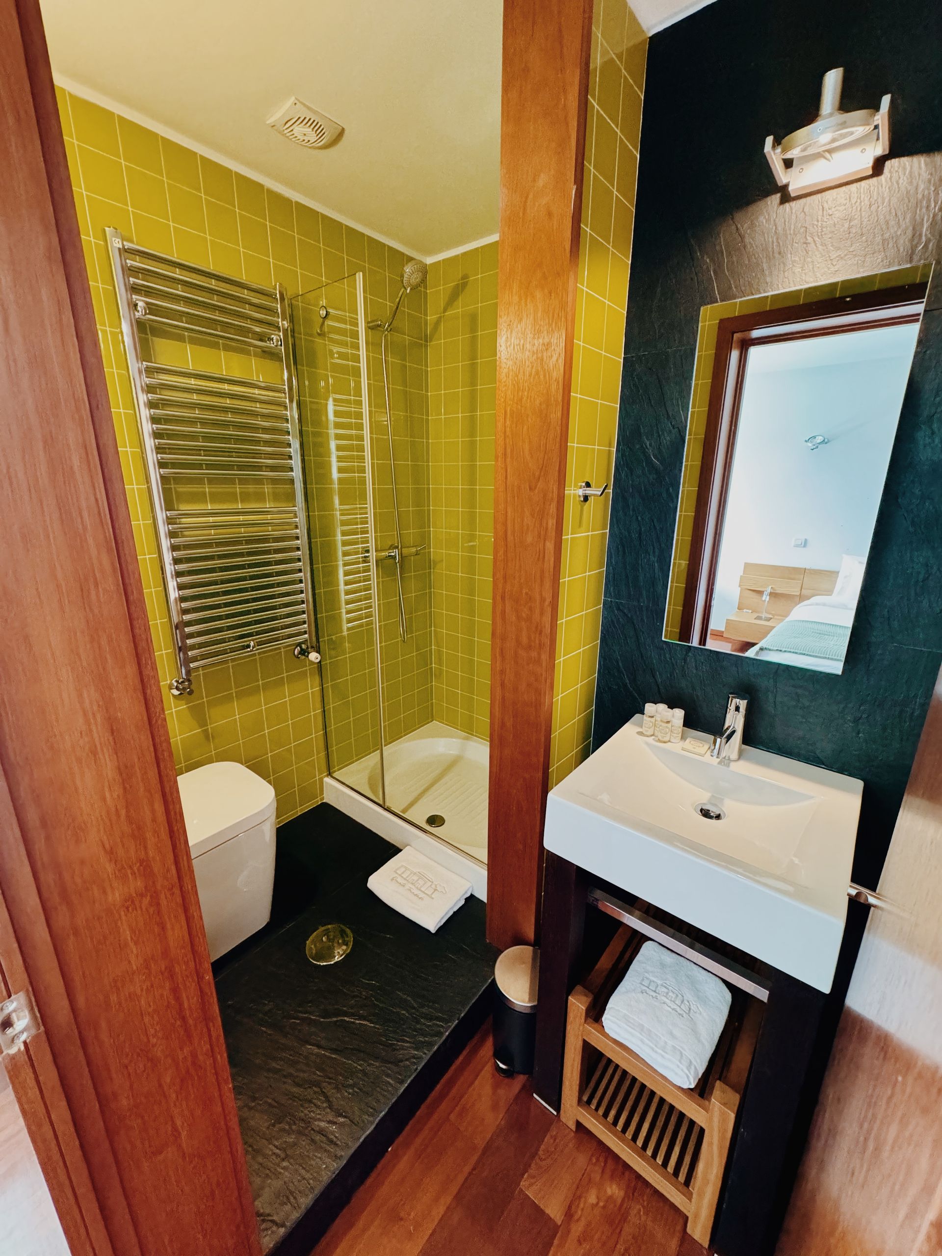Um banheiro com azulejos amarelos, pia e espelho