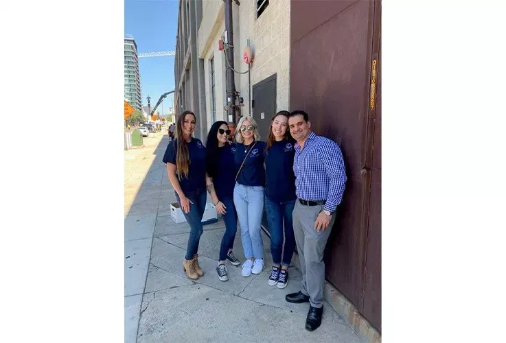 Del Mar Dental doctor and staff standing next to each other on a sidewalk in front of a building.