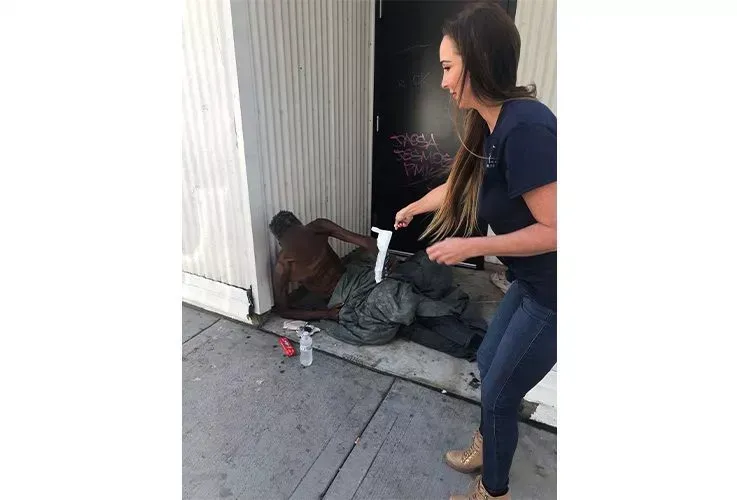 Del Mar Dental staff helping a homeless man on the street.