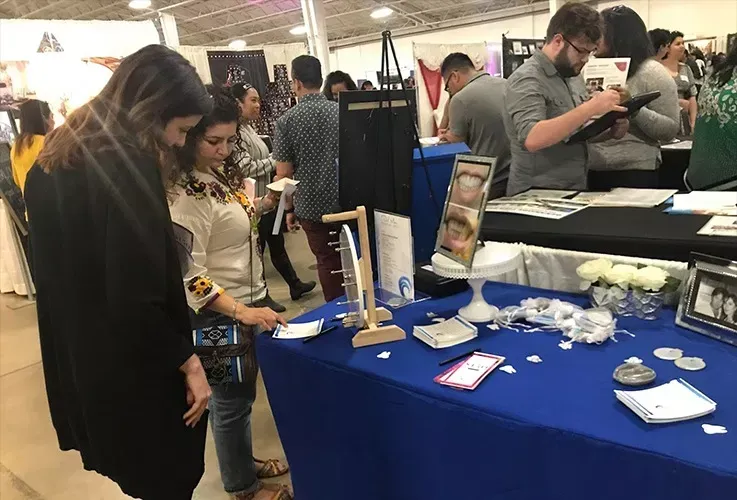 people looking at a table with a sign that says dental on it.