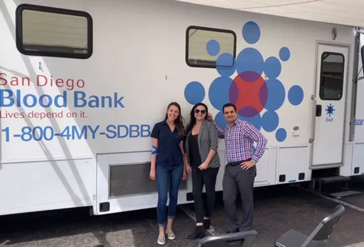 Del Mar Dental Arts staff posing if front of a San Diego Blood Bank van.