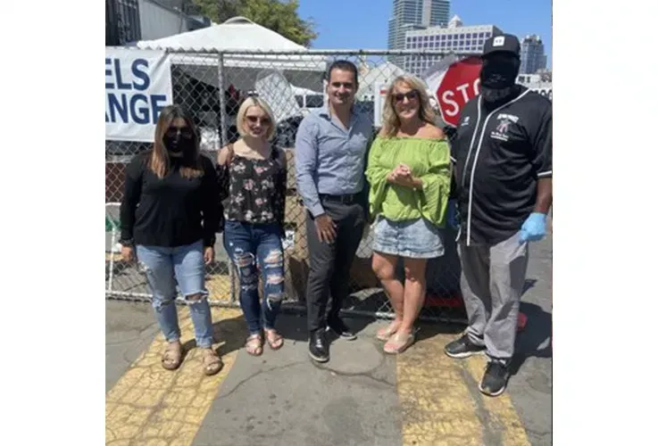 Del Mar Dental Arts staff standing next to each other in front of a chain link fence.
