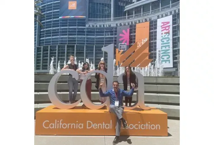 Del Mar Dental Arts staff standing in front of a california dental association sign.