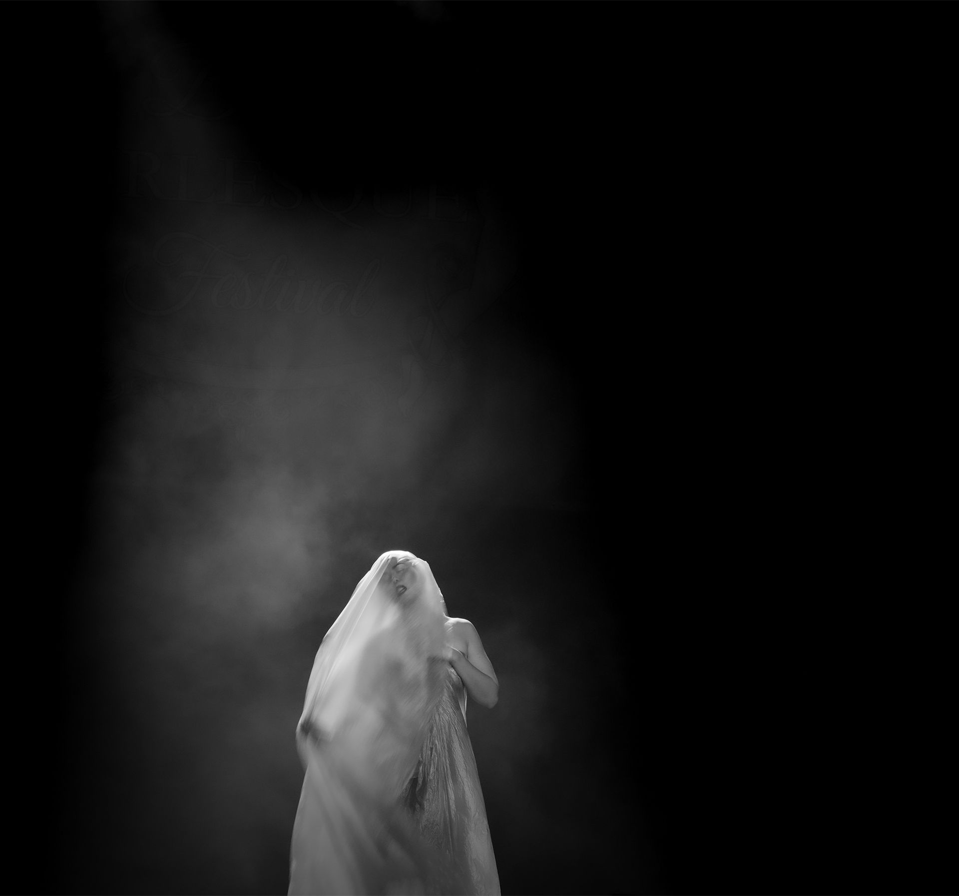 Silhouette drapée d'un tissu blanc sur fond sombre, peut-être de fumée.