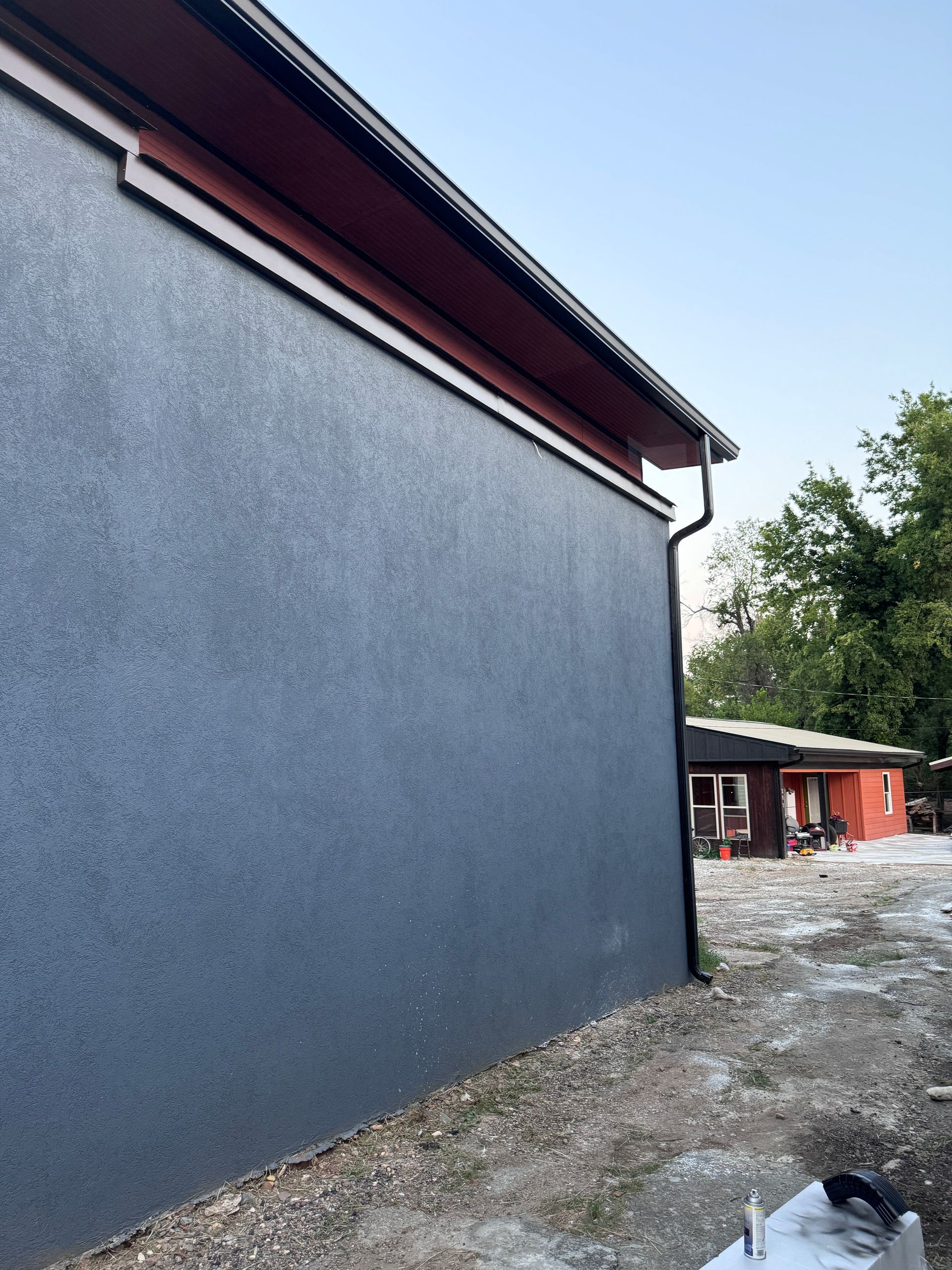 A blue building with a red roof is under construction