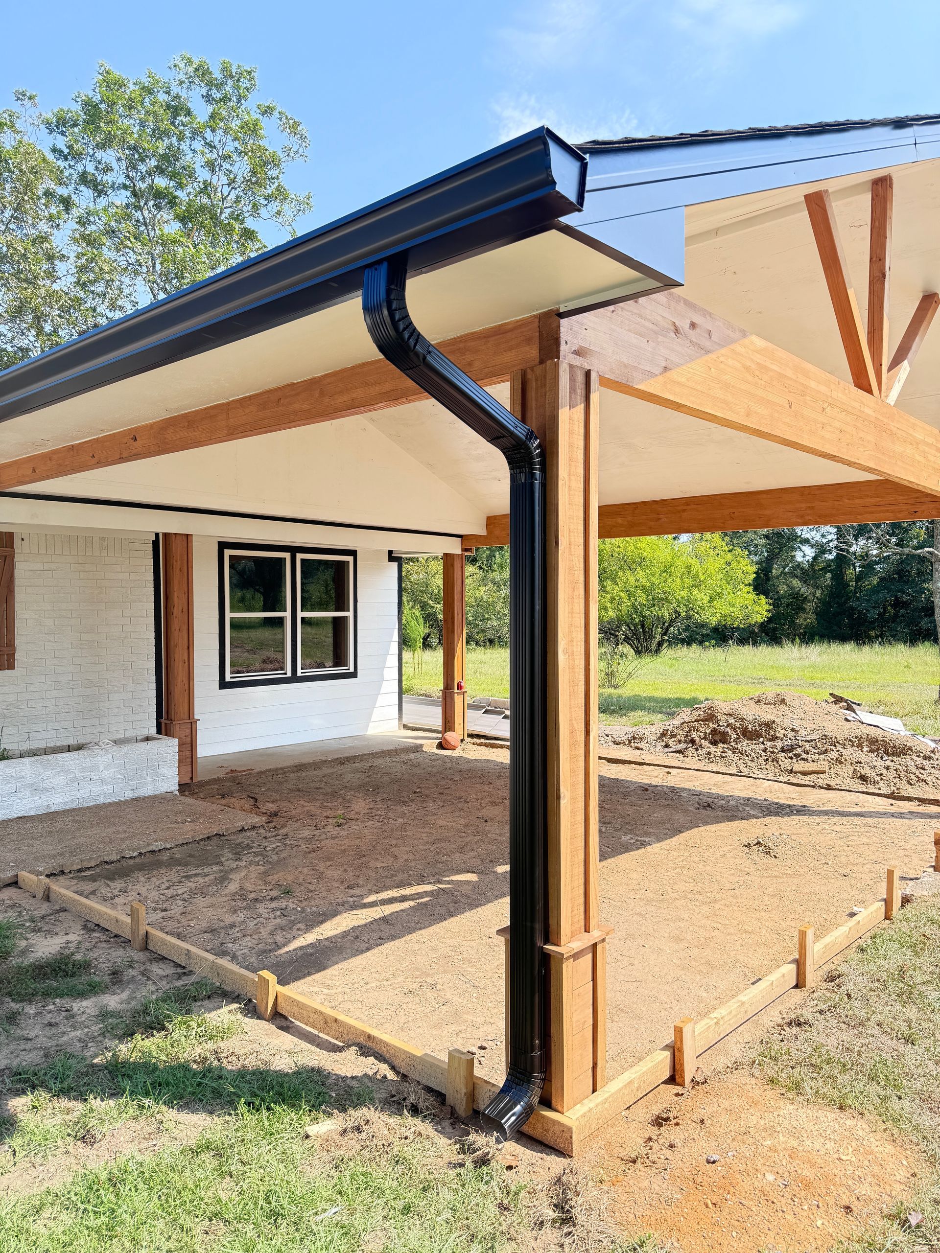 A house with a covered porch and a black gutter.