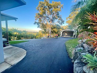A Driveway Leading To A House With Trees On The Side Of It — Elite Bitumen & Asphalt In Mackay, QLD