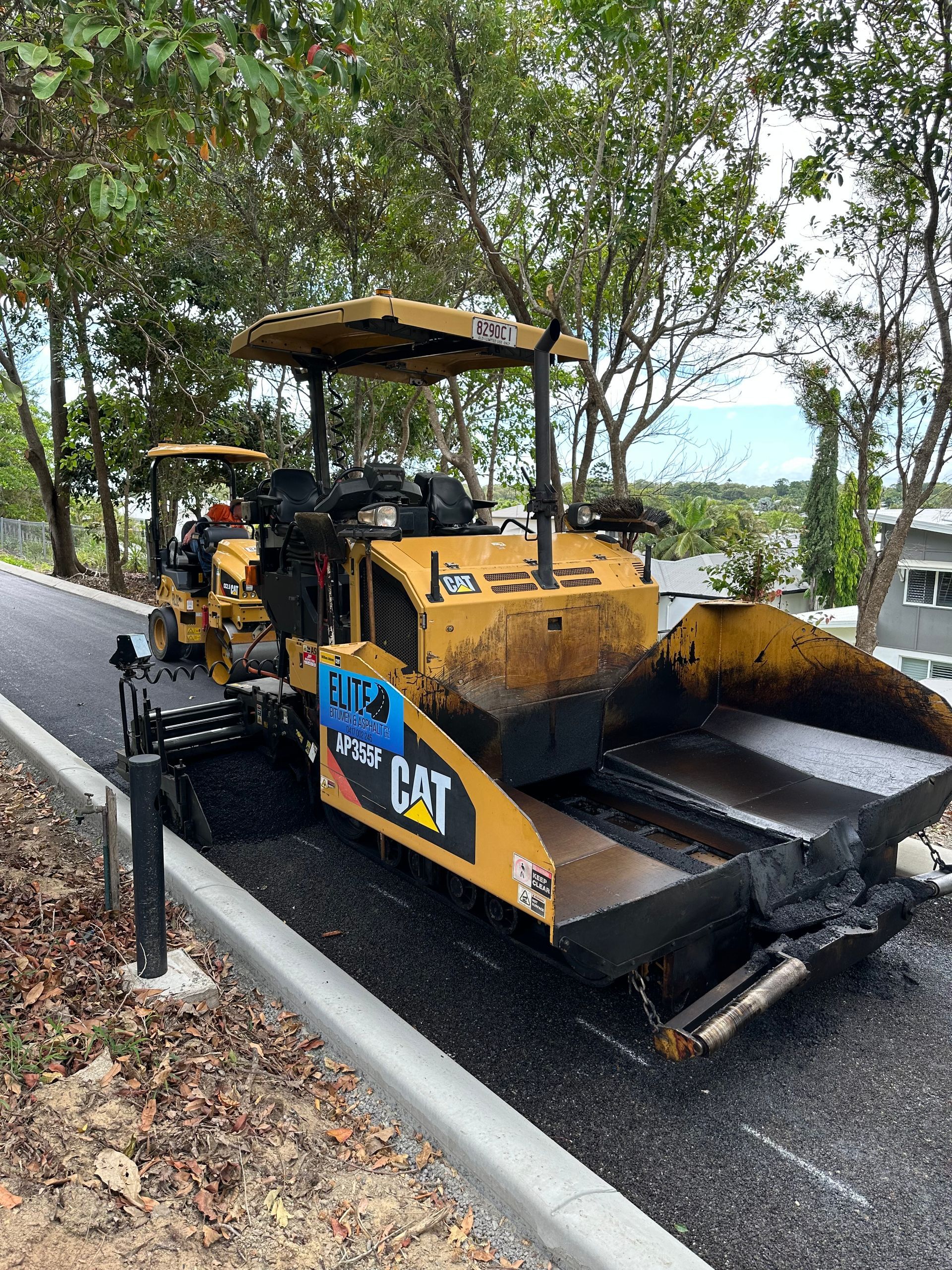 A Yellow Machine Is Driving On An Asphalt Pathway — Elite Bitumen & Asphalt In Mackay, QLD
