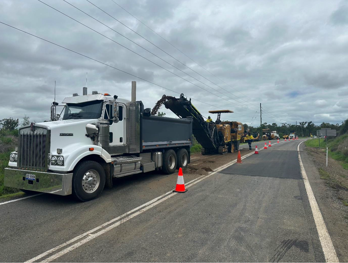 A Construction Vehicle Is Working On A Road — Elite Bitumen & Asphalt In Mackay, QLD