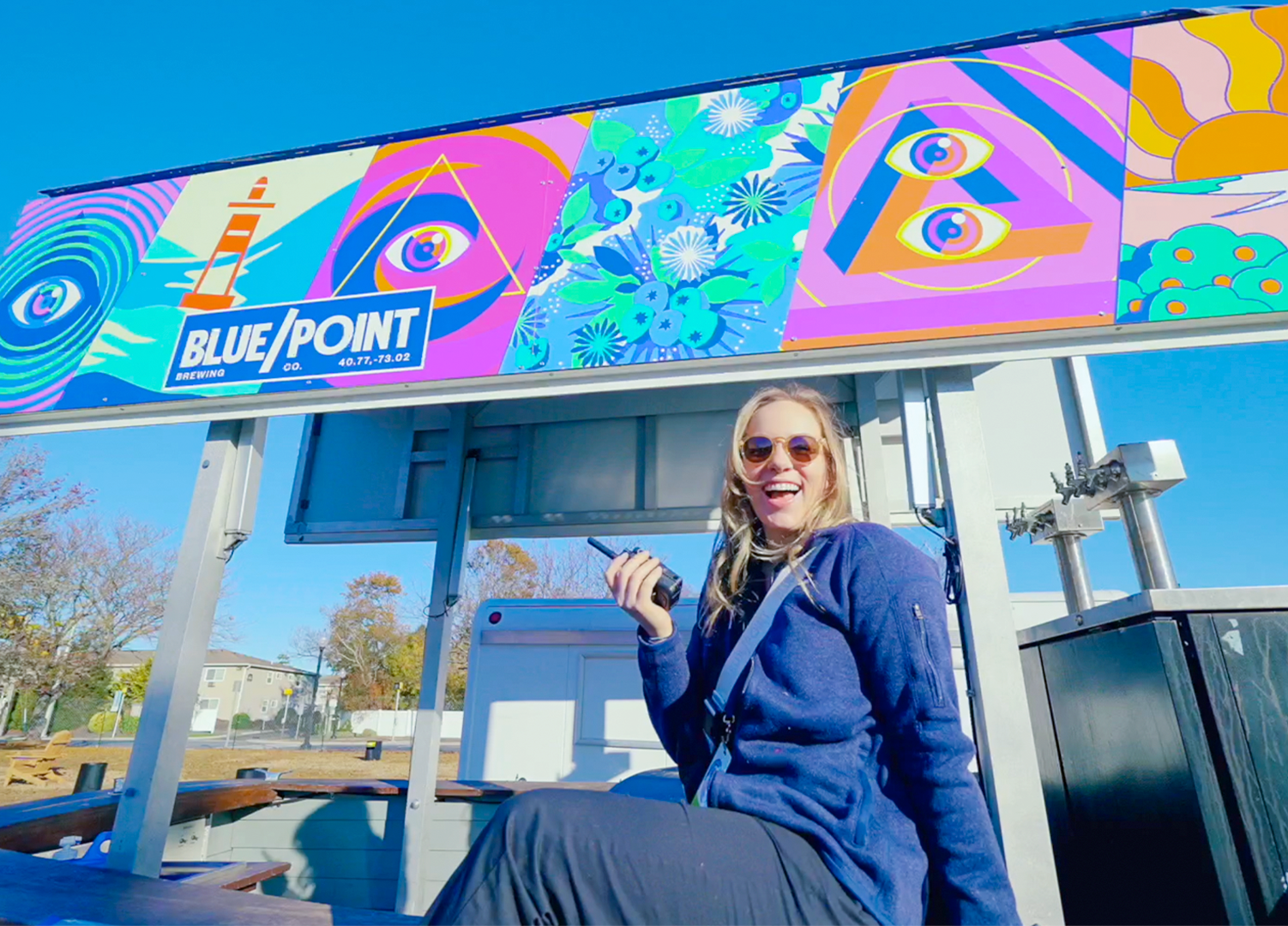 Girl with a walkie talkie sitting on a custom branded boat activation.