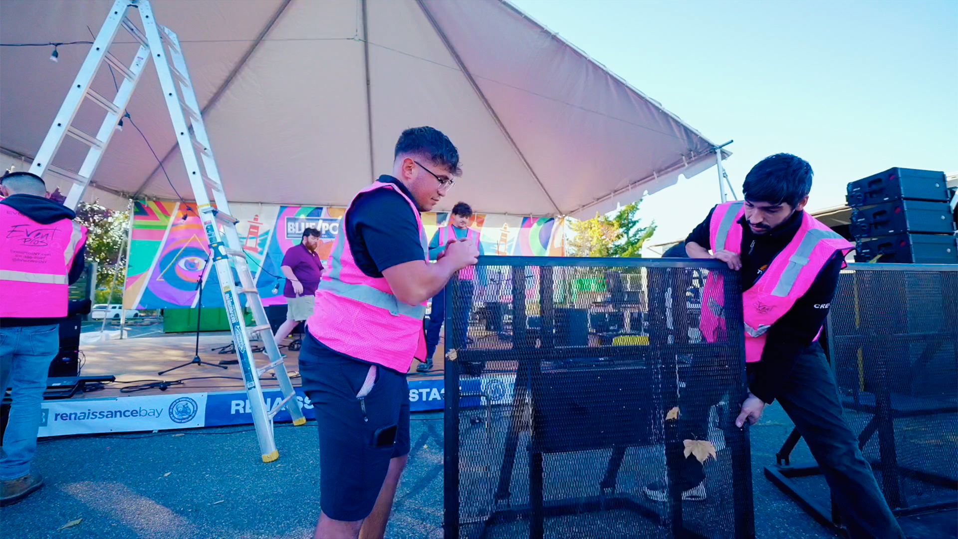 Two workers setting up barricades for a concert