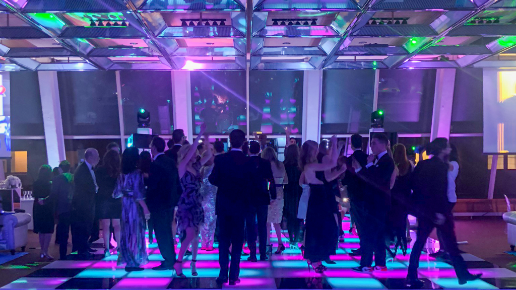 A multi-color LED dance floor with a crowd dancing on it