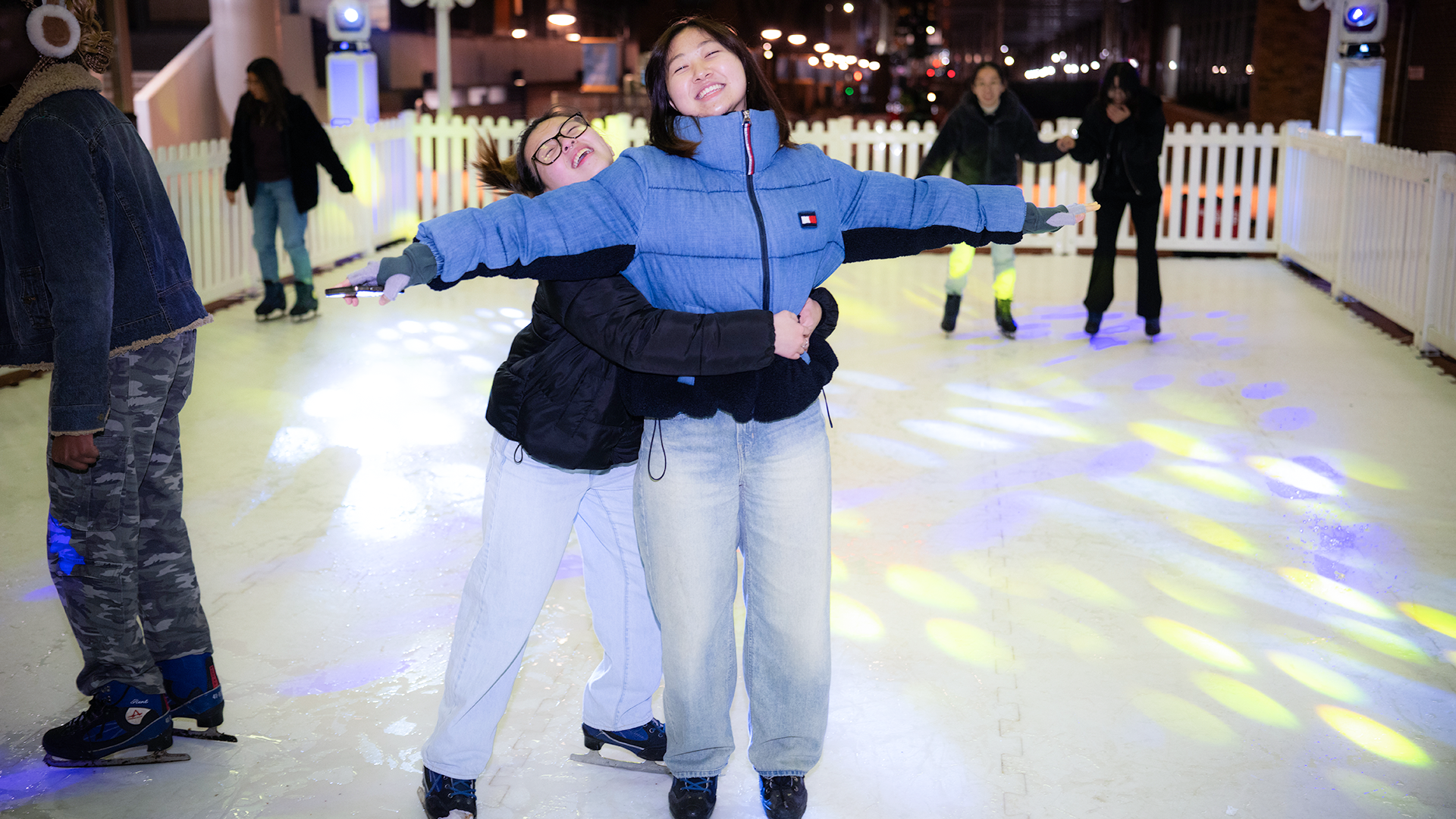 Two girls skating on a synthetic ice rink