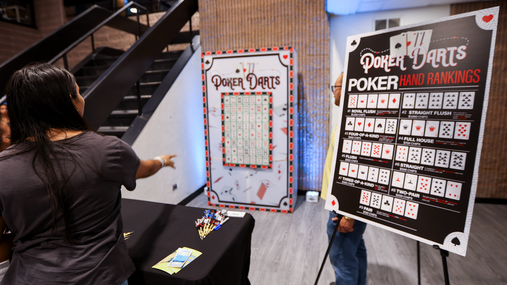 A woman throwing a dart at a dart board