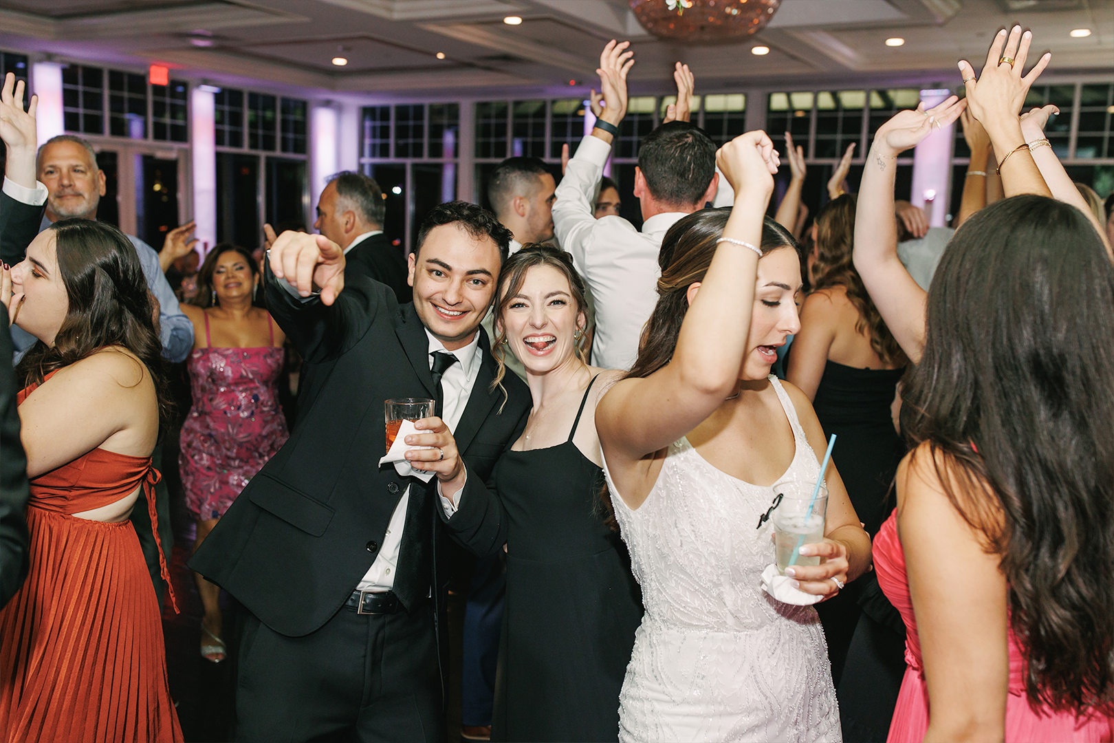 Wedding guests having fun on a dance floor with the bride and groom