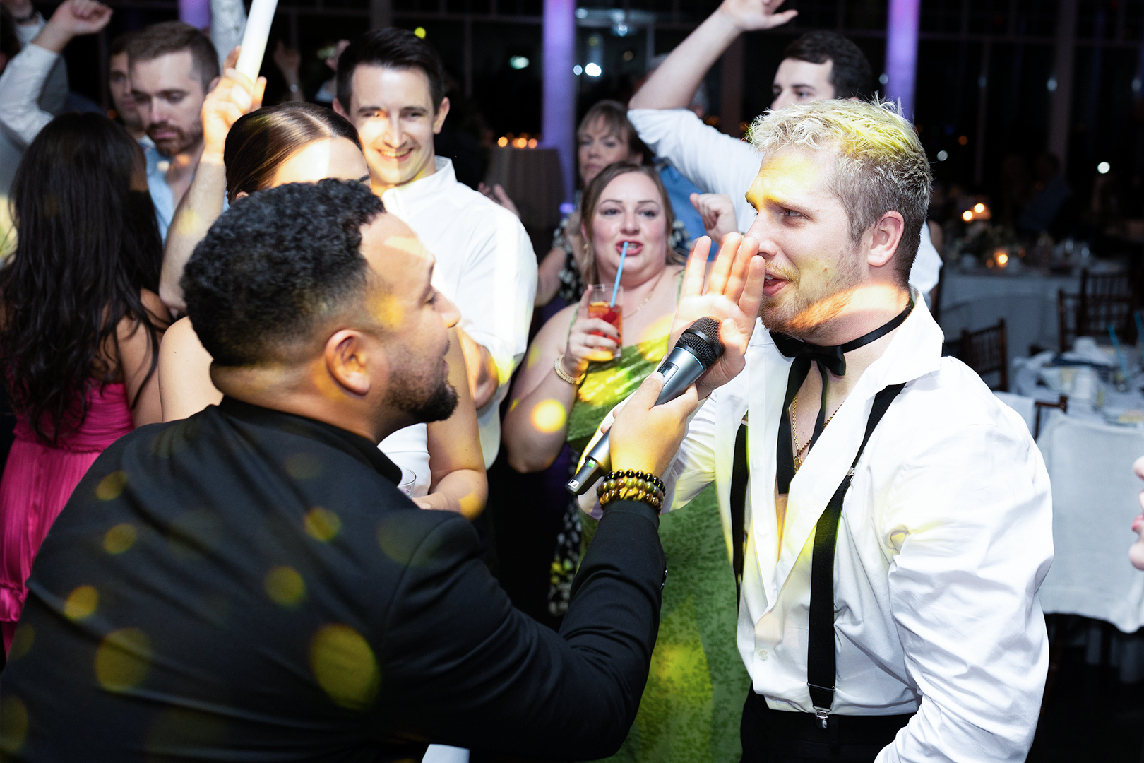 wedding MC holding microphone to singing guest
