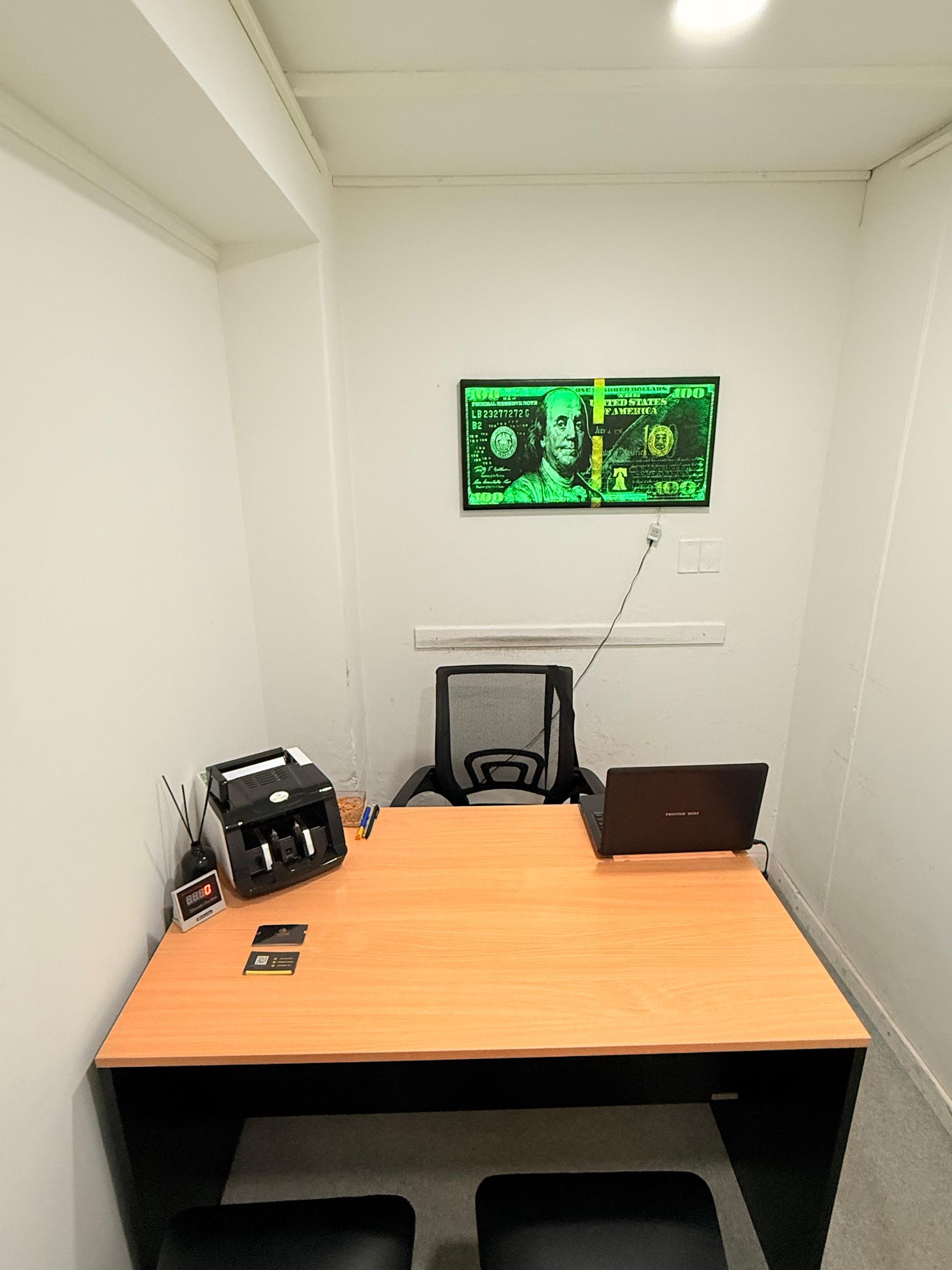 Una pequeña oficina con un escritorio, una silla y una computadora portátil.