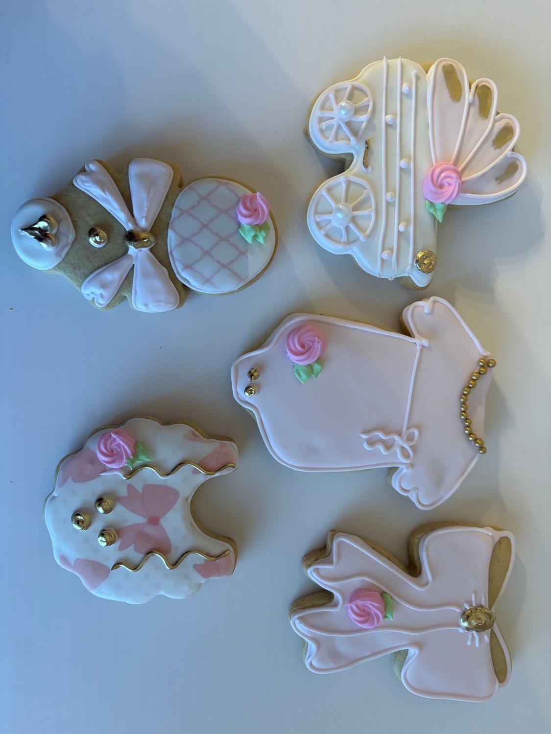 Five pastel acrylic fish and shell charms with pearl accents arranged on a blue background