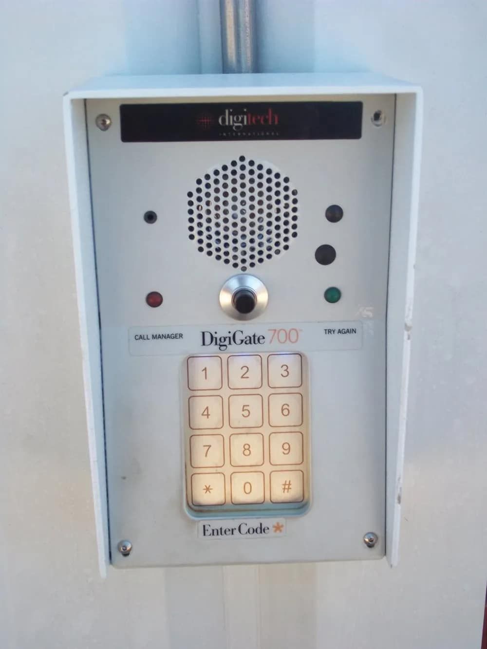 White Digigate 700 keypad with speaker, buttons, and microphone mounted on a wall.
